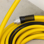Close-up of a coiled yellow ToughLite PRO hose with black accents and "GORILLA TOUGHLITE" text.