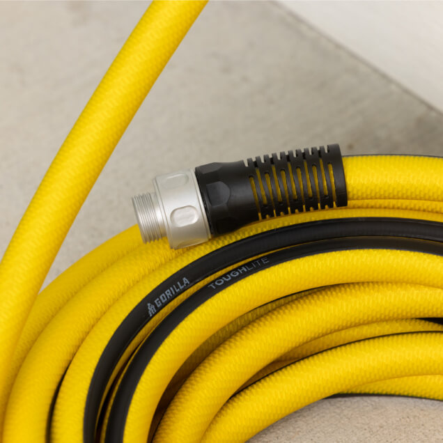 Close-up of a coiled yellow ToughLite PRO hose with black accents and "GORILLA TOUGHLITE" text.